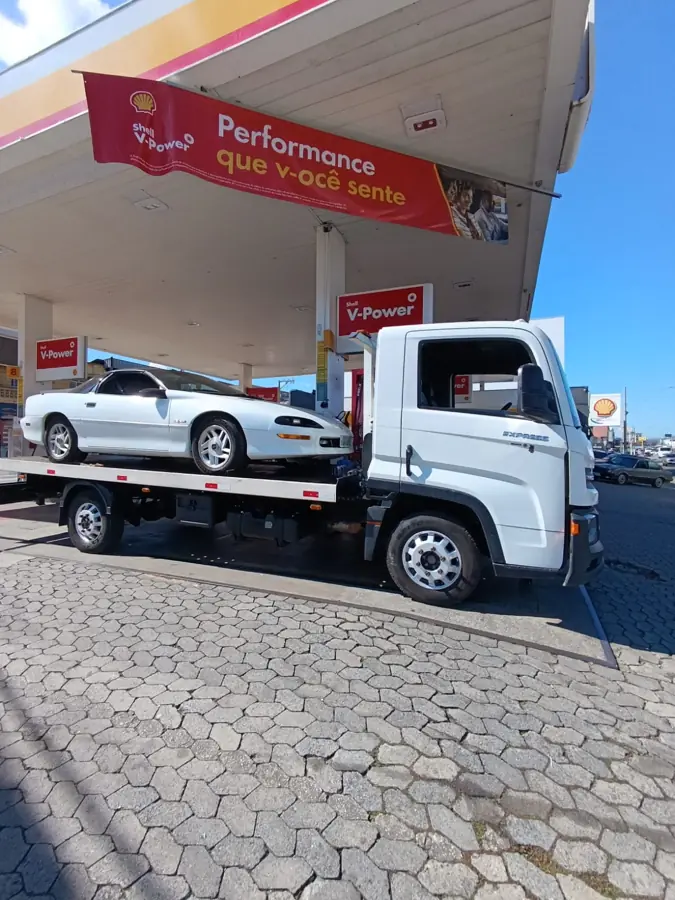 Camaro branco sendo transportado na plataforma do guincho