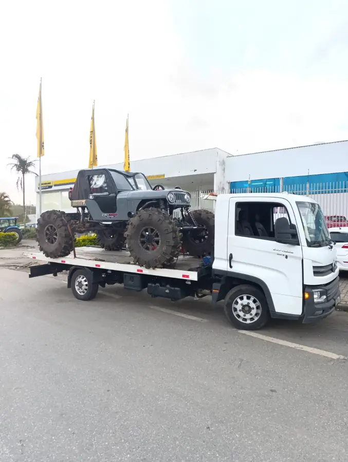 Jipe 4x4 de pneus grandes preso à plataforma do guincho